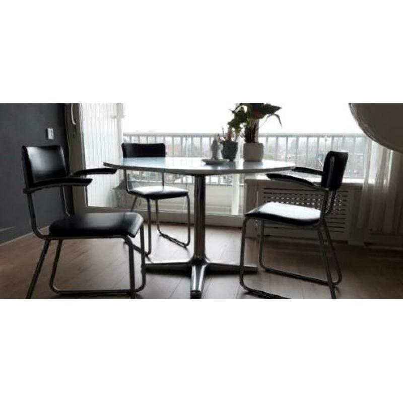 Ronde witte eettafel met 4 zwarte vintage stoelen