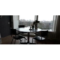 Ronde witte eettafel met 4 zwarte vintage stoelen
