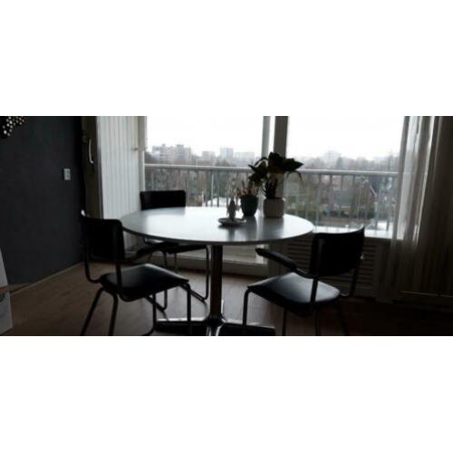 Ronde witte eettafel met 4 zwarte vintage stoelen