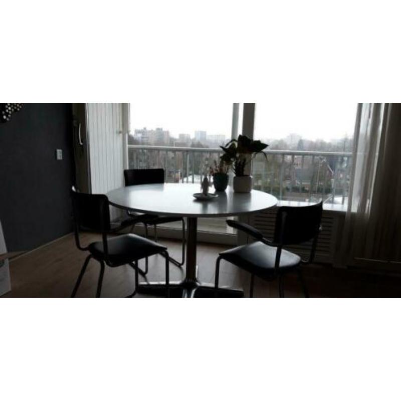 Ronde witte eettafel met 4 zwarte vintage stoelen