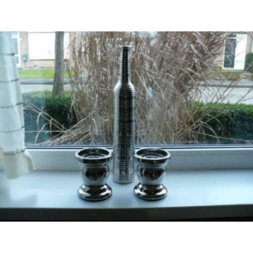 leuke zilverkleurige kaarskandelaar en fles