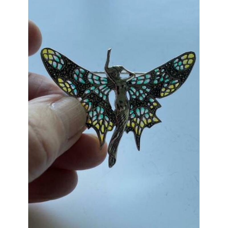 Zilveren vlinder broche met er in: vrouwen motief verwerkt.