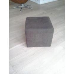 Donkerbruine poef van ribstof.